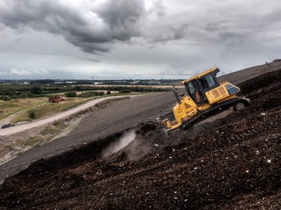a bulldozer on a slope moving waste on a landfill site 1